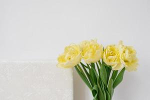 geel bloemen tulpen Aan de achtergrond van een wit bruiloft of familie foto boek. dol herinneringen in foto's voor geheugen