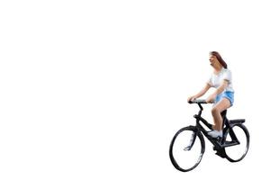 miniatuur figuur rijden op een fiets geïsoleerd op een witte achtergrond foto