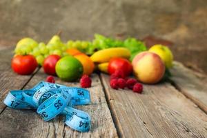 fruit, groenten, meten plakband Aan houten achtergrond. foto