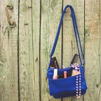 dingen van Open dame tas. schoonheidsmiddelen en vrouwen accessoires viel uit van blauw handtas. afgezwakt afbeelding. foto