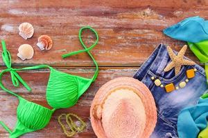 zomer vrouwen kleding en accessoires hoed, het baden pak, denim korte broek, pareo, schelpen. top visie. foto