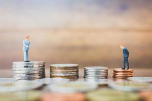 miniatuur ondernemers staan op geld met een houten achtergrond