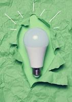 wit glas lamp Aan groen verfrommeld papier, nieuw creatief ideeën concept foto