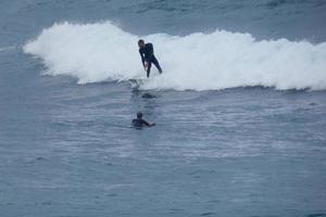 surfers rijden klein oceaan golven foto