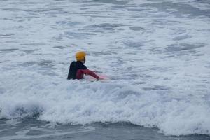 jong atleten beoefenen de water sport van surfing foto