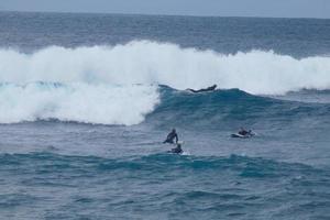 jong atleten beoefenen de water sport van surfing foto