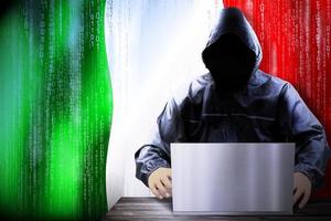 anoniem met een kap hacker en vlag van Italië, binair code - cyber aanval concept foto