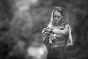 jong toerist vrouw met lang golvend haar- looks Bij haar slim kijk maar telefoon terwijl wandelen, kopiëren ruimte. zwart en wit foto. foto