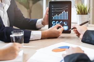 bedrijf ontmoeting, Aziatisch groep Mens, vrouw brainstorm analyseren diagram gegevens van kosten plan, bespreken in bord kamer, gebruik makend van touchpad of laptop computer Aan tafel of bureau. mensen werken conferentie kamer. foto