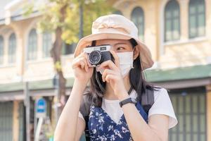 reiziger, reizen Aziatisch jong vrouw of meisje gebruik camera nemen foto oud stad- straat en stad toerisme Aan gelukkig zonnig dag. backpacker toerist Aan vakantie reis in zomer of vakantie weekend.