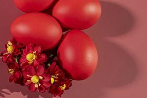 kleurrijk eieren, symboliseert Pasen, Aan een kleurrijk achtergrond en bloemen foto