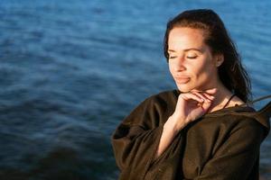 portret gelukkig glimlachen vrouw Aan strand. glimlachen sensueel brunette poseren foto