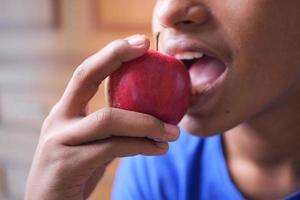 kind jongen aan het eten appel dichtbij omhoog foto