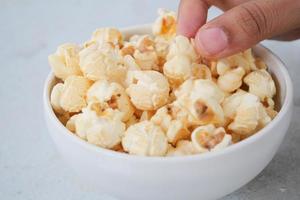 popcorn in een kom op houten bureau foto