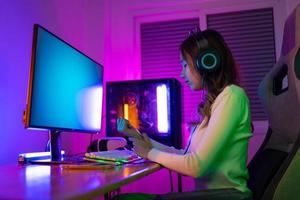 pols pijn concept. gamer en e-sport online van Aziatisch vrouw spelen online computer video spel met verlichting effect, uitzending streaming leven Bij huis. foto