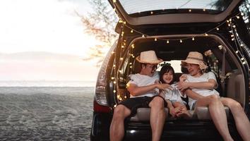 gelukkig familie met auto reizen en camping weg reis. zomer vakantie in auto in de zonsondergang, pa, mam en dochter gelukkig op reis genieten samen het rijden in vakantie, mensen levensstijl rijden door auto. foto