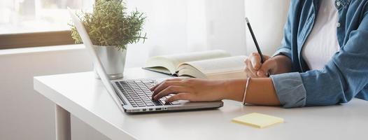 dichtbij omhoog hand- van hoog school- leerling vrouw aan het studeren, aan het leren online academisch les in Universiteit bibliotheek gebruik makend van de laptop computer, concept van onderwijs. foto