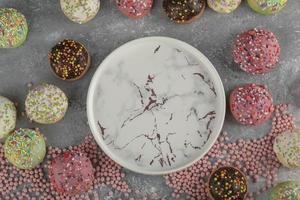 kleurrijke zoete kleine donuts met hagelslag en een marmeren schotel foto