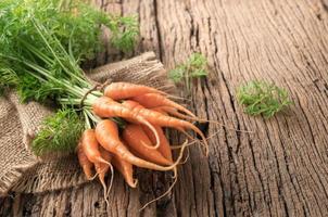 vers biologisch wortels met groen bladeren Aan oud hout foto