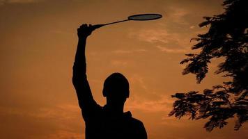 silhouetten Mens is Holding de badminton racket foto