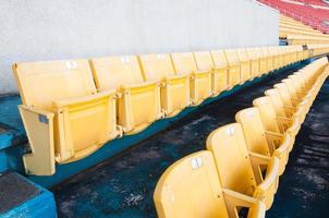 leeg geel stoelen Bij stadion, rijen van stoel Aan een voetbal stadion, selecteer focus foto