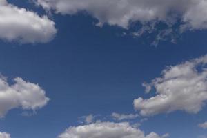 witte pluizige wolken in een blauwe lucht foto