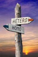 hetero of homo - wegwijzer met twee pijlen, zonsondergang lucht in achtergrond foto