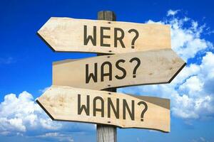 vragen in Duitse - houten wegwijzer met drie pijlen, lucht met wolken in achtergrond foto