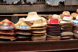 boten verkoop hoeden - handgemaakt het weven - damnoen saduak drijvend markt is een populair toerist bestemming dat Europeanen en Chinese Leuk vinden naar reizen met de traditioneel manier van leven van de dorpelingen. foto