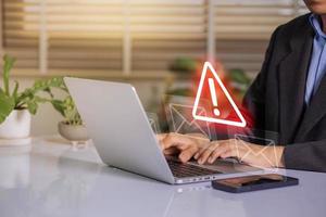 zakenman gebruik makend van laptop met elektronisch e-mail hacken en spam waarschuwing symbool. cyber aanval netwerk, virus, spyware, cyber veiligheid en cybercriminaliteit. foto