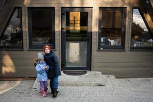 ouder broer knuffel jonger zus tegen land klein cabine huis. foto