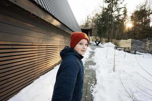 jongen wandelen in de buurt uit rooster klein huis in de bergen. foto