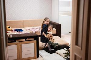 twee zussen Bij huis Aan de sofa knuffelen strak samen. foto