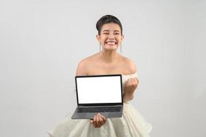 jong Aziatisch mooi bruid houding met mockup laptop computer in hand- foto