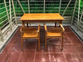 houten tafel en houten zitplaatsen Aan bruinachtig rood keramiek foto