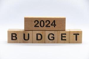 begroting 2024 tekst gegraveerde Aan houten blokken met wit Hoes achtergrond. budgettering bedrijf concept. foto