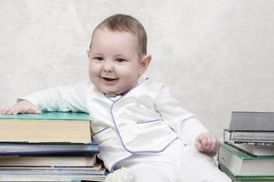 weinig kind tussen boeken. gelukkig zes maand oud baby jongen in een stack van boeken. de concept van vroeg kinderjaren onderwijs. foto