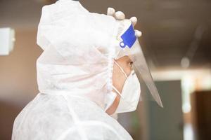 mannetje dokter in een beschermend masker en pak in profiel voor coronavirus infectie. foto