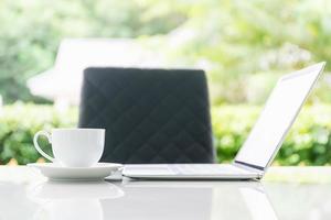 laptop computer en kop van koffie Aan de tafel in ochtend- foto