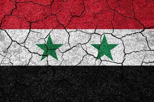 aardbevingen in Syrië, vlag Syrië Aan een muur met scheuren van een aardbeving foto