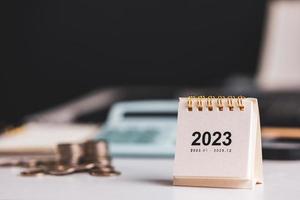 klein 2023 jaar kalender Aan bureau met financieel beheer achtergrond. concept van planning en doelen voor financieel beheer en bedrijf groei foto