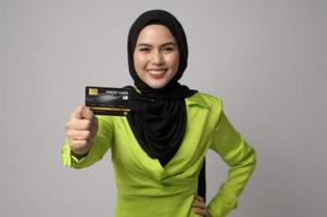 mooi moslim vrouw met hijab Holding credit kaart over- wit achtergrond studio, boodschappen doen en financiën concept. foto