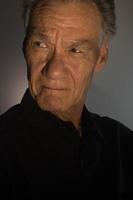 donker humeurig portret van een ouder Mens in laag licht vervelend een zwart overhemd foto