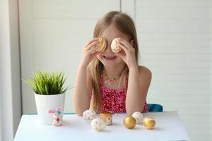 hand- weinig meisje schilderij patronen eieren met goud verf. gelukkig Pasen. foto