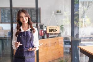 portret van een vrouw, een koffie winkel bedrijf eigenaar glimlachen prachtig en opening een koffie winkel dat is haar eigen bedrijf, klein bedrijf concept. foto