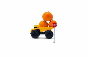 concept voor niet doen overbelasten wanneer brengen spullen. een foto na sommige bewerkingen, een geel vrachtauto brengt sommige sinaasappels en omgedraaid over.