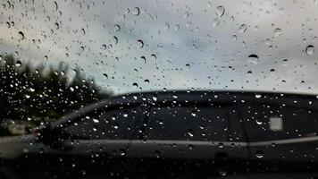 regen laten vallen Aan de auto glas. weg visie door auto venster met regen druppels, het rijden in regen. foto