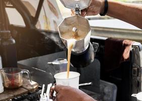 barista maken koffie met mokka pot foto