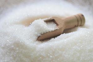 suiker Aan houten lepel, wit suiker voor voedsel en snoepgoed toetje snoep hoop van zoet suiker kristallijn korrelig foto
