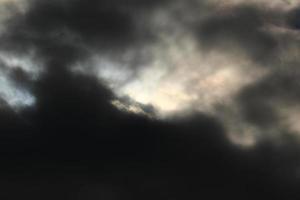 zon schijf achter verlicht wolken foto